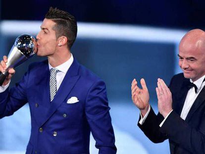 Cristiano Ronaldo besa el trofeo a mejor jugador de 2016 ante la mirada de Gianni Infantino, presidente de la FIFA.