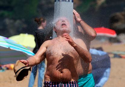Un hombre se refresca debajo de una ducha de una playa de Biarritz (Francia), este miércoles.