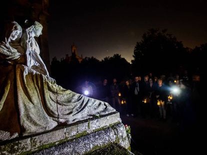 Participantes en una visita nocturna contemplan una tumba labrada por el escultor Francisco Asorey en el cementerio de Vigo.