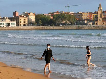 Una mujer se baña en la mañana de hoy lunes en la playa de San Lorenzo de Gijón. 