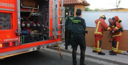 Bomberos y Guardia Civil, ante la vivienda incendiada en Riba-roja en la que ha fallecido un matrimonio.