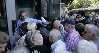 Un director abre una oficina bancaria para los pensionistas en Atenas.