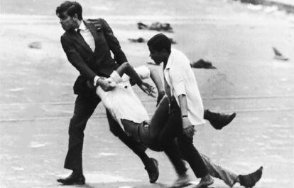 Dos hombres con uno de los estudiantes muertos cerca de la embajada de EE UU, en Rio de Janeiro, en 1968. 