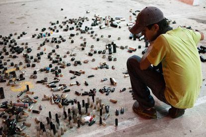 Un jóven observa con atención cientos de casquillos de balas en el Estado de Táchira, cuna de las protestas de los últimos dos meses.