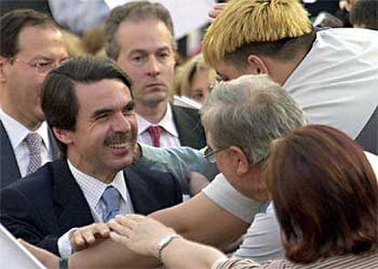 Simpatizantes del PP saludan a José María Aznar a su llegada a la plaza de toros de Murcia.
