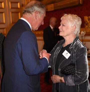 Carlos de Inglaterra conversa con la actriz Judi Dench en la recepción celebrada para los actores británicos poseedores de un Oscar..