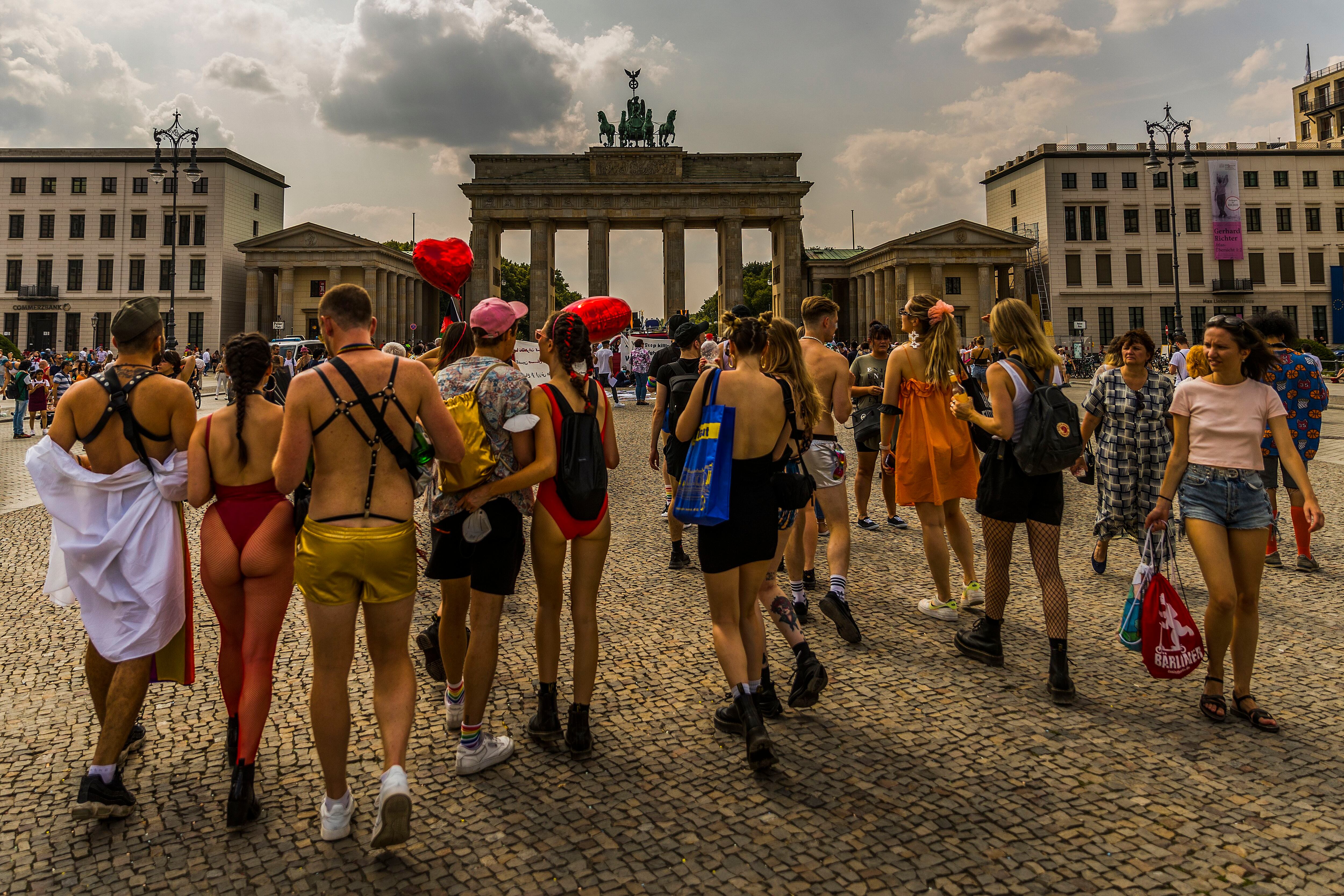 Un grupo de gente pasea por la puerta de Brandemburgo al finalizar el desfile del día del orgullo LGBT en Berlín.