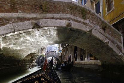 Unas góndolas pasan bajo los puentes de Venecia.