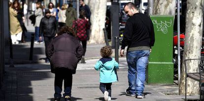 Un padre pasea junto a su hija por la calle.