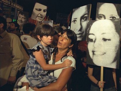 Una madre y su hija asisten a una manifestación organizada por las Madres de Plaza de Mayo y miembros de la organización H.I.J.O.S., en una fotografía de archivo.