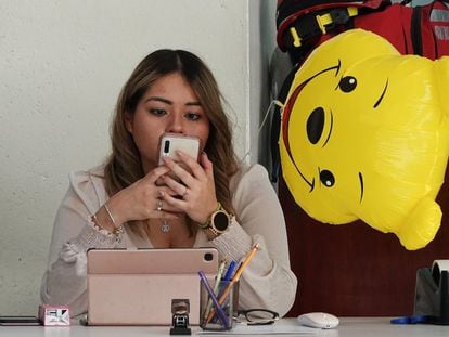 Una mujer revisa su teléfono celular en una oficina en Ciudad de México.