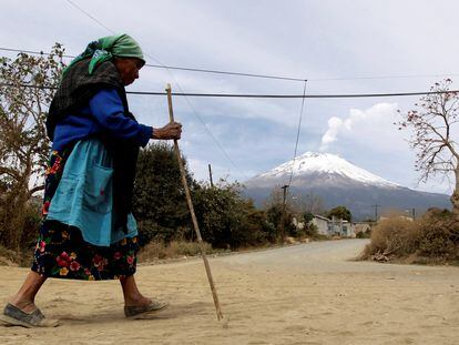 A local resident walks as the Popocatepetl volcano belches a column of steam in Xalitzintla, in the state of Puebla, located 125 km east of Mexico City, February 1, 2012. Civil protection officials from the Puebla government are giving evacuation training to residents of this village located 12 km from the Popocatepetl volcano, ahead of a possible eruption, after an increase of volcanic activity and ash eruptions have been registered recently.   REUTERS/Henry Romero REFILE - REMOVING LOCATION CLASSIFICATION