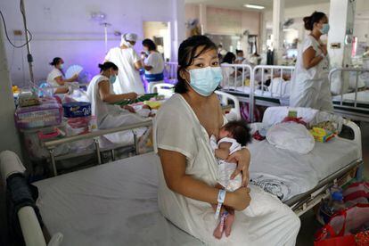Krystyn Anne Plácido, de 30 años, posa con su hija en una de las abarrotadas salas de la llamada fábrica de bebés de Manila.