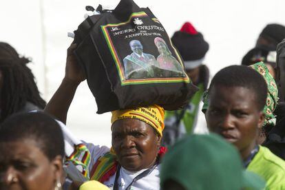 Imagen del presidente zimbabuense, Robert Mugabe, y su mujer, Grace, en el bolso de una asistente a la conferencia de su partido en Masvingo en este mes de diciembre.