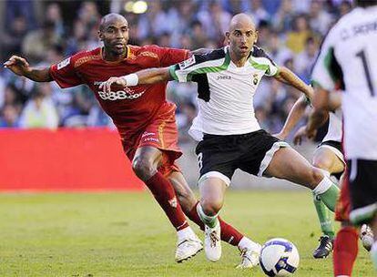 Colsa protege el balón ante el acoso del sevillista Kanouté.