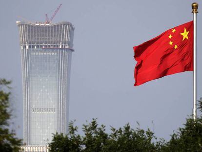 La bandera nacional china ante el rascacielo más alto de Pekín, en construcción.