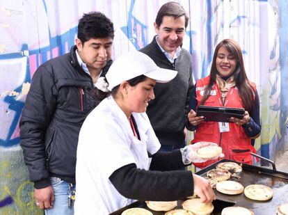 Carlos Torres Vila, consejero delegado del BBVA, visita el puesto de arepas de Dary Guerrero a las afueras de Bogotá. 