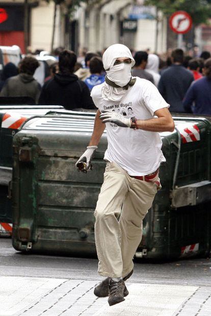 Un joven  lanza una piedra contra la <i>Ertzaintza</i> en  Bilbao, el 21 de agosto de 2009.