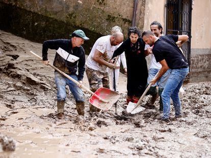 Un grupo de vecinos ayuda a una anciana en la localidad de Cantiano.