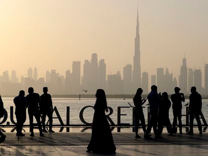 Varias personas contemplan el skyline de Dubái, con la torre Burj Khalifa en el centro.