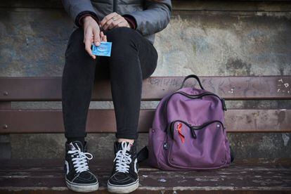 Una adolescente sujeta un preservativo. 