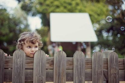 Un niño observa a la gente, mientras otros juegan y se divierten. 