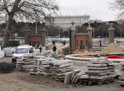 Una de las cancelas de forja  desmontadas ayer en la Puerta del Río. Al fondo, el Palacio Real.