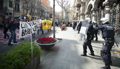 Agentes de la Guardia Urbana se protegen frente a los manifestantes.