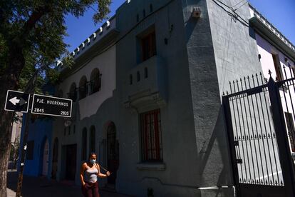Una mujer camina afuera de la casa donde vivirá el presidente Gabriel Boric.