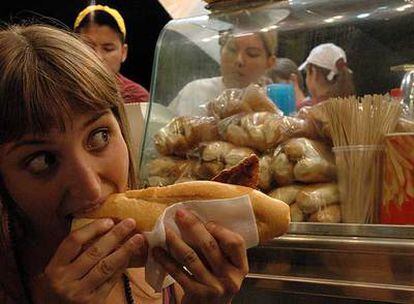 Una joven sacia el apetito en uno de los tradicionales puestos de comida de las fiestas de la Paloma.
