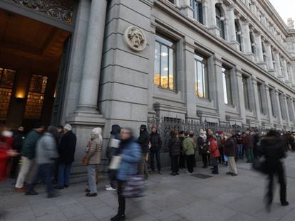 Numerosas personas hace colas ante la sede del Banco de España en Madrid para comprar deuda pública española.