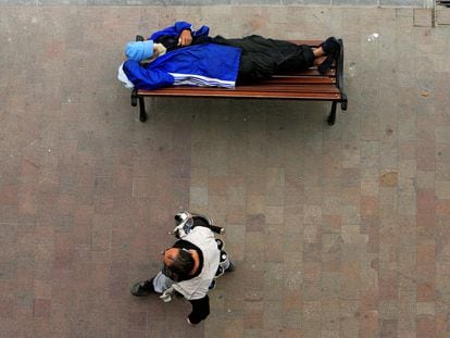 Un hombre duerme en un banco en Beirut, Líbano.