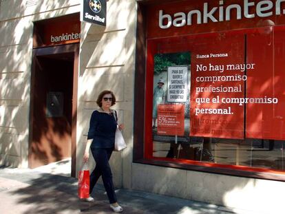 Una mujer pasa por delante de una oficina de Bankinter.