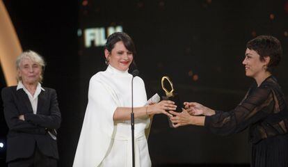 Jaione Camborda entrega la Concha de oro de 'O corno' a la productora Andrea Vázquez. De fondo, la presidenta del jurado, Claire Denis.