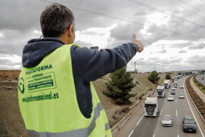 Un miembro de la Asociación de Transportistas en el puente de la M-45, durante el quinto día de paros en el sector de los transportes.