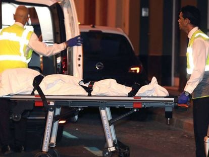 Miembros de los servicios funerarios trasladan el cadáver de la mujer en Las Palmas de Gran Canaria.