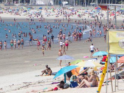 Personas disfrutan del sol y las altas temperaturas este domingo, día de las elecciones gallegas, en la playa de La Fuente en Vigo, Pontevedra.