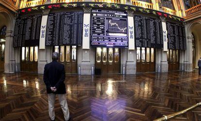 Un hombre mira los paneles de la Bolsa de Madrid