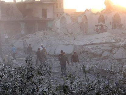 Vecinos de Taftanaz caminan entre los destrozos de un bombardeo del régimen.