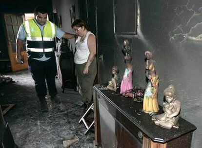 Un agente consuela a la propietaria del restaurante La Fuente, en Masca, que ha quedado destrozado por el fuego.