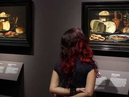 Una mujer observa dos bodegones de la pintora flamenca Clara Peeters, en una exposición en el Museo del Prado.