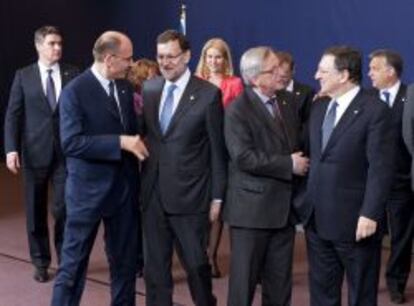 El presidente del Gobierno, Mariano Rajoy (c-i), saluda al primer ministro de Italia, Enrico Letta (i), ante el primer ministro de Luxemburgo, Jean-Claude Juncker (2d), y el presidente de la Comisión Europea, José Manuel Durão Barroso (d), entre otros, tras la foto de familia de los líderes de la UE que participan en la reunión extraordinaria del Consejo Europeo celebrada el 25 de mayo de 2013.