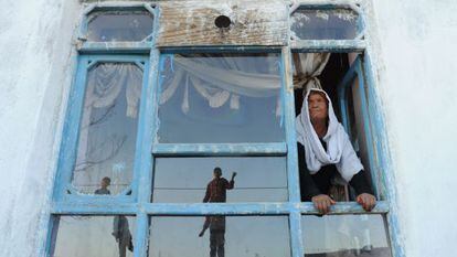 La viuda afgana Bibikoh se asoma a la ventana de su casa en Zanabad.