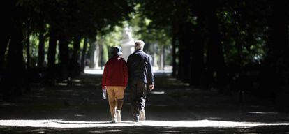 Dos jubilados pasean por el parque del Retiro en Madrid.