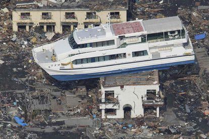 Un transbordador se balancea sobre una casa en la localidad de Otsuchi, en la prefectura de Iwate.