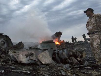 Militares entre los restos del avión derribado en Ucrania.