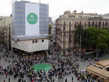 Una gran pancarta y un abanico verde en el suelo en la protesta de los arquitectos