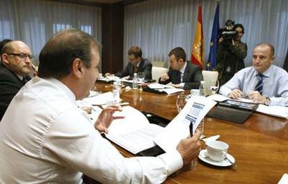 El ministro de Industria, Miguel Sebastián (derecha), atiende las explicaciones del secretario general de Turismo, Juan Mesquida (en primer término), durante una reunión, hoy, en el ministerio con los responsables de Turespaña.