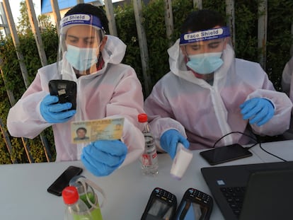 Personal médico en Chile registra un documento de identidad como parte del protocolo contra la covid-19 antes de un partido de fútbol.