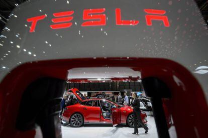 (FILES) In this file photo taken on March 4, 2015 visitor are seen at the booth of US electric carmaker Tesla Motors, during the press day of the Geneva Car Show in Geneva.